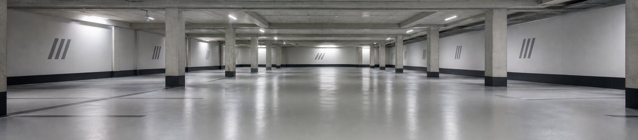 Leere Tiefgarage mit instand gesetztem Stahlbetontragwerk und beschichtetem Boden